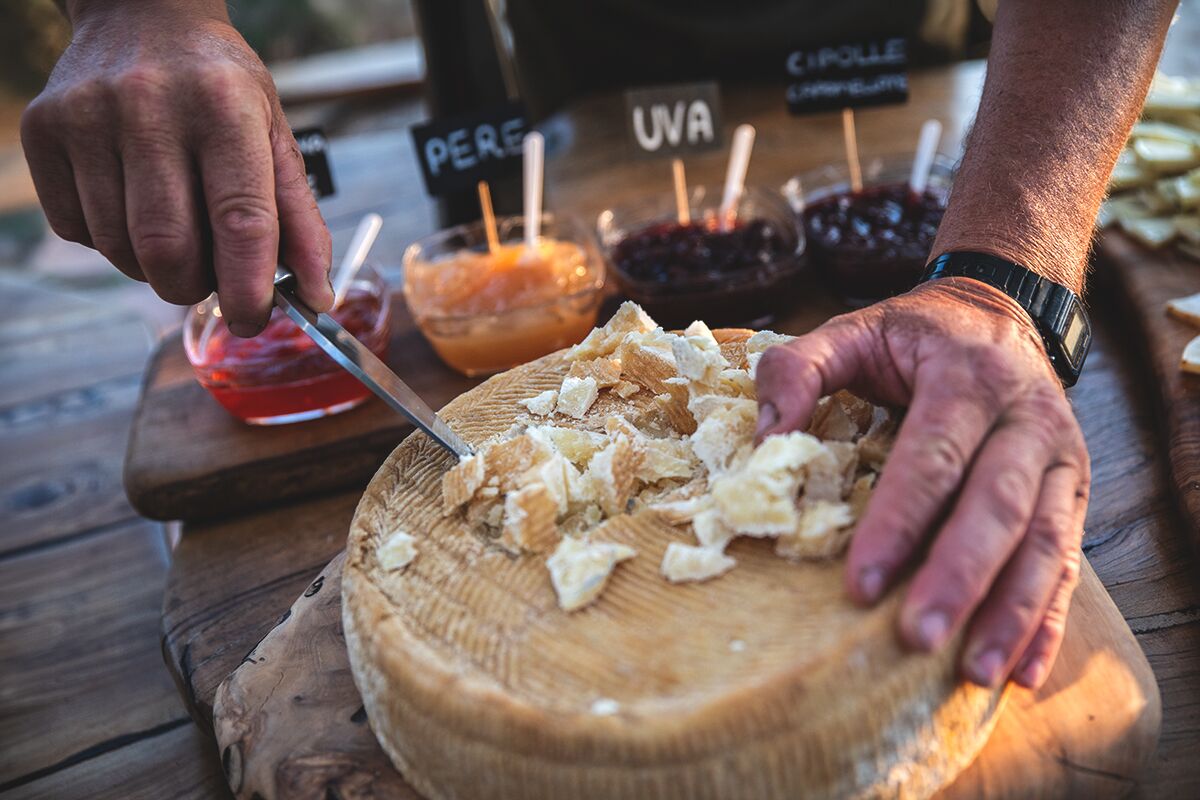 Pecorino tagliato dalla forma intera, con le composte di pere, uva e cipolle