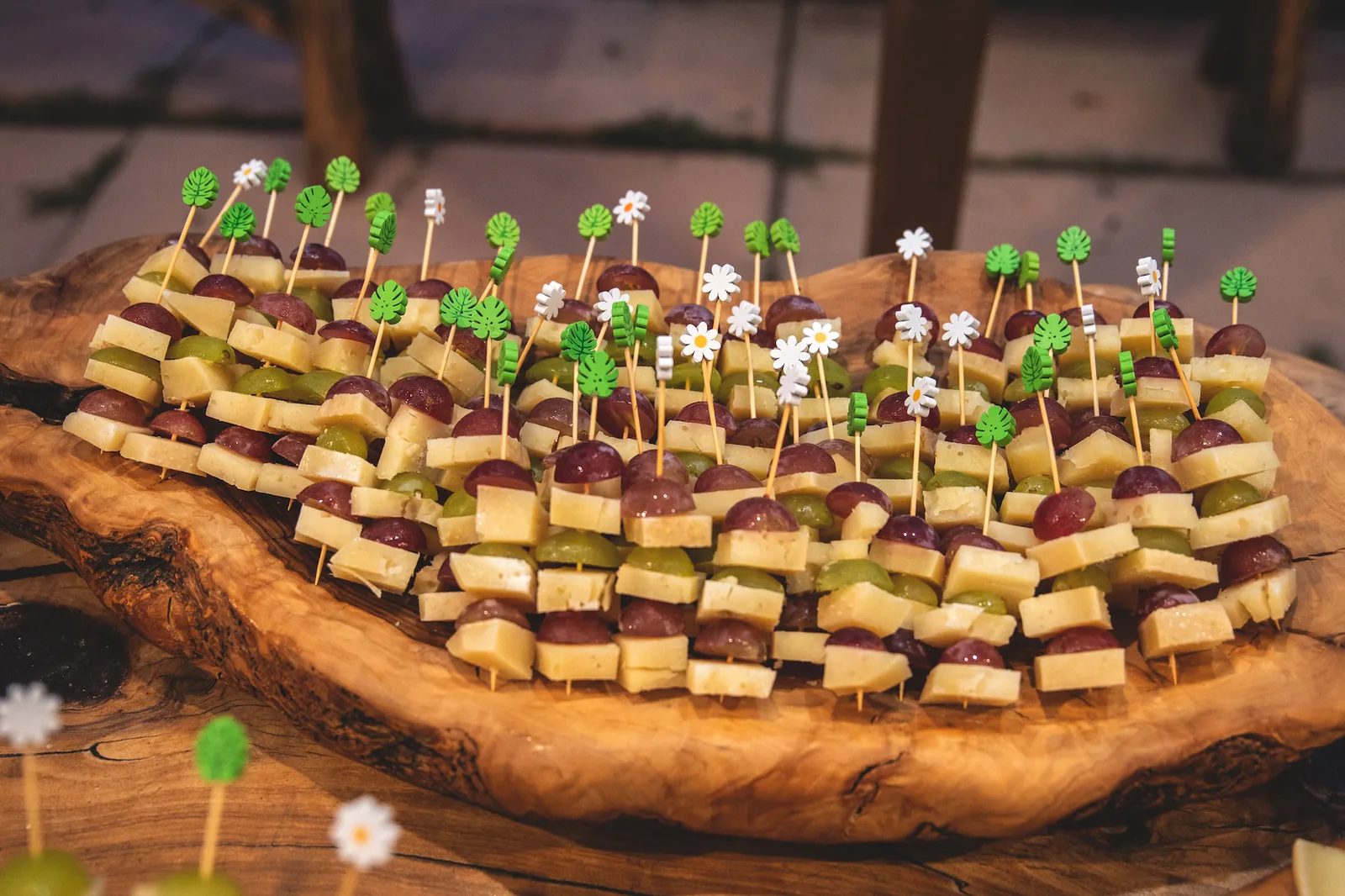Spiedini di formaggio e uva sul tagliere di legno d’ulivo