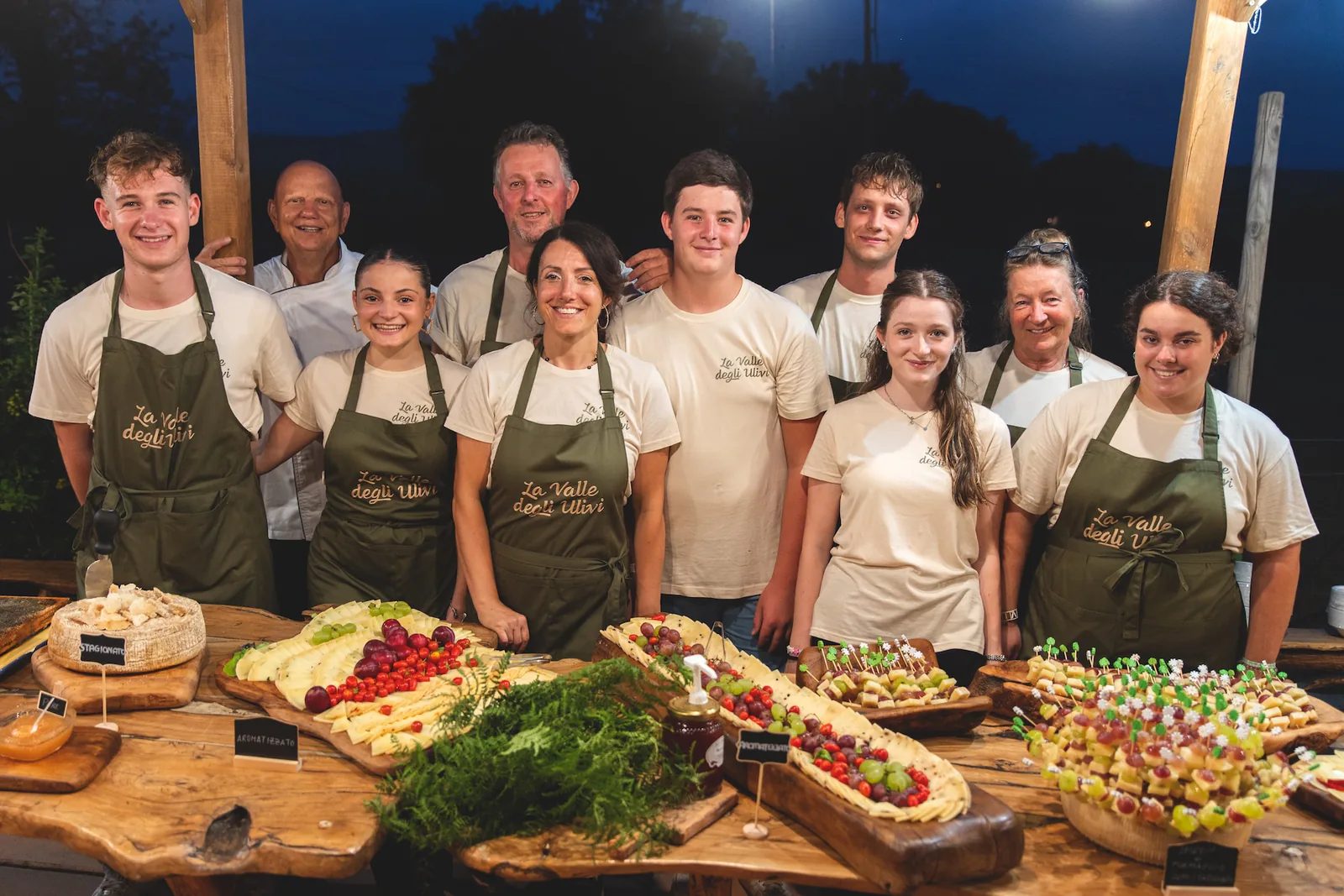 Lo staff della Valle degli Ulivi, con i grembiuli dell'azienda, dietro il buffet di una festa serale