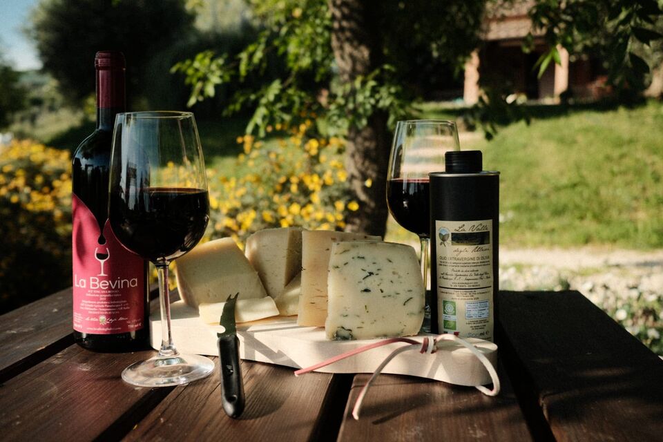 Tavolo con pecorini, vino La Bevina e olio della Valle degli Ulivi