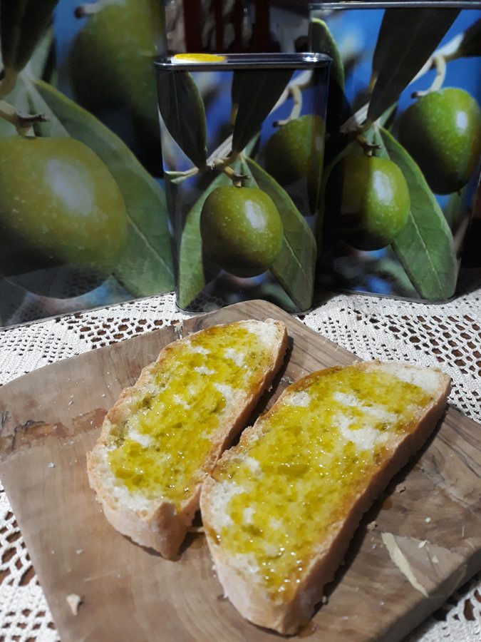 Bruschetta con l'olio extravergine nuovo della Valle degli Ulivi, davanti alle latte dell'olio