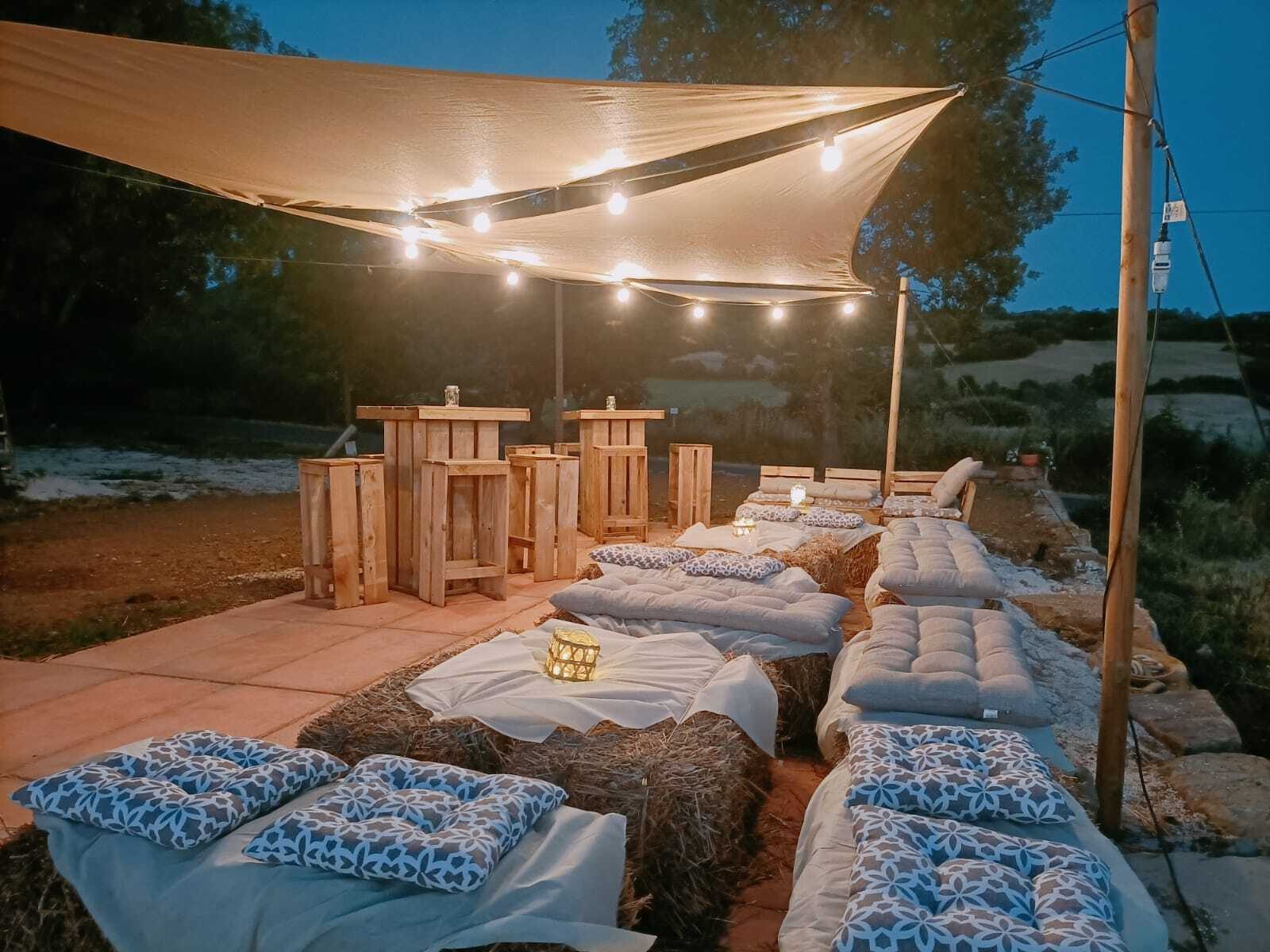 Il giardino del Punto Vendita allestito per la sera, con le luci e i cuscini